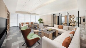 A spacious living area with a sofa, chairs, a coffee table, and a TV.