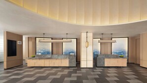 A modern hotel lobby with two reception desks, a large window with a city view, and a curved ceiling design.