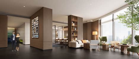 A spacious lobby with a modern design, featuring a seating area with a sofa and chairs, a bookshelf, and a large window offering a city view.
