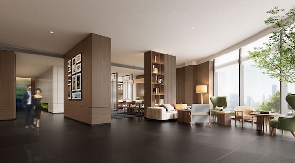Un vestíbulo espacioso con un diseño moderno, que incluye una zona de estar con sofá y sillones, una estantería y un ventanal con vistas a la ciudad.