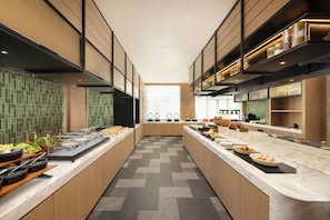 A modern kitchen with a long counter, built-in appliances, and a tiled backsplash.