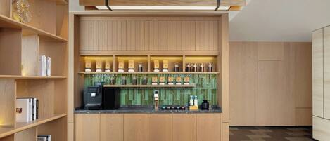 A modern kitchen with wooden cabinetry, a coffee machine, and a tiled backsplash.