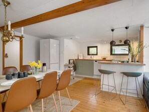 Eine moderne Küche mit einer zentralen Kochinsel, Barhocker und einem Essbereich mit Stühlen.