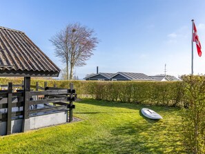 Ein Wohngebiet mit einem Haus, einer Flagge und einem kleinen Boot auf dem Rasen.