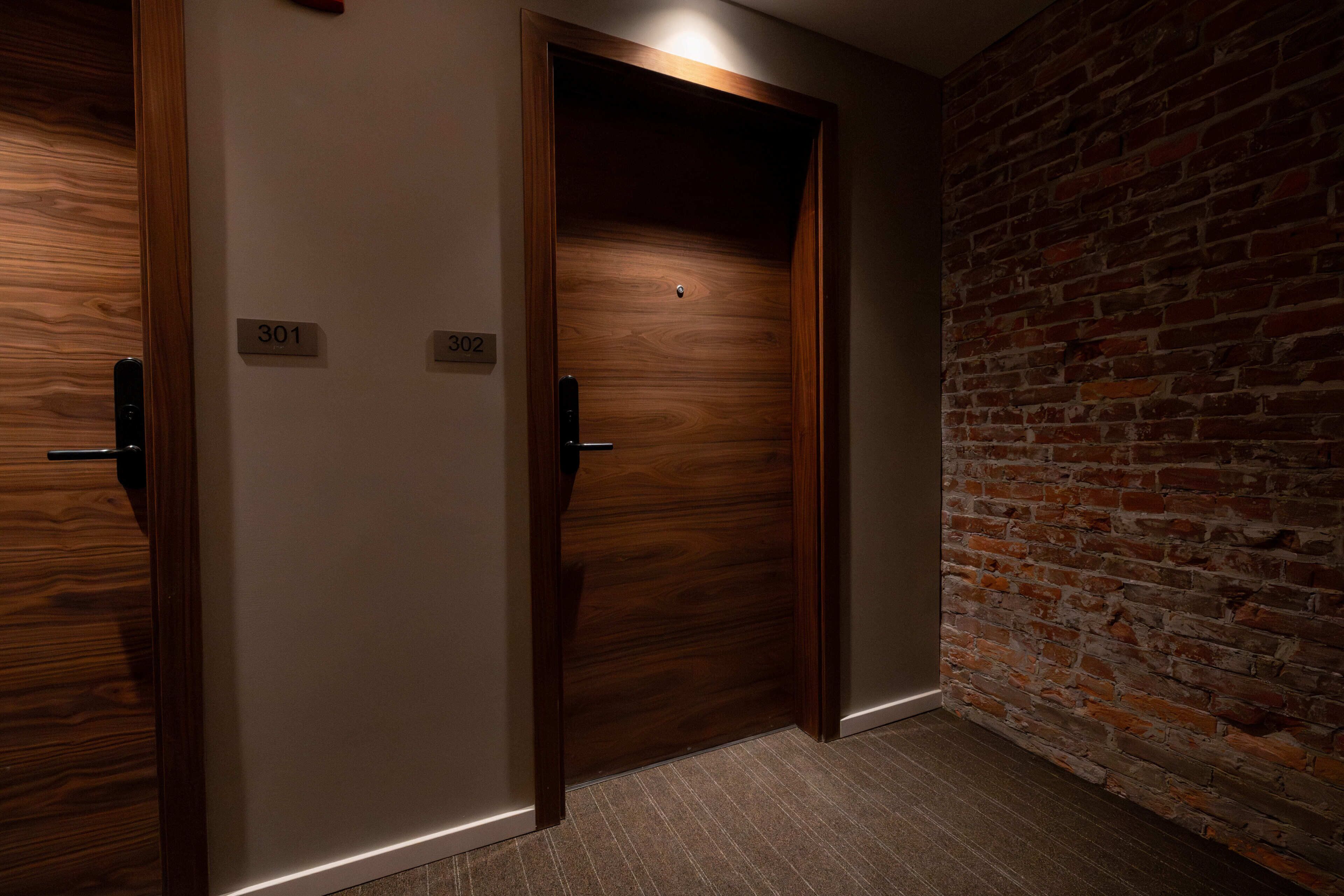 A hallway with two wooden doors, each marked with a number.