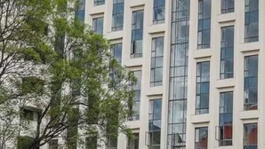 Um edifício de vários andares com design arquitetônico moderno, com vários janelões retangulares e sacadas.