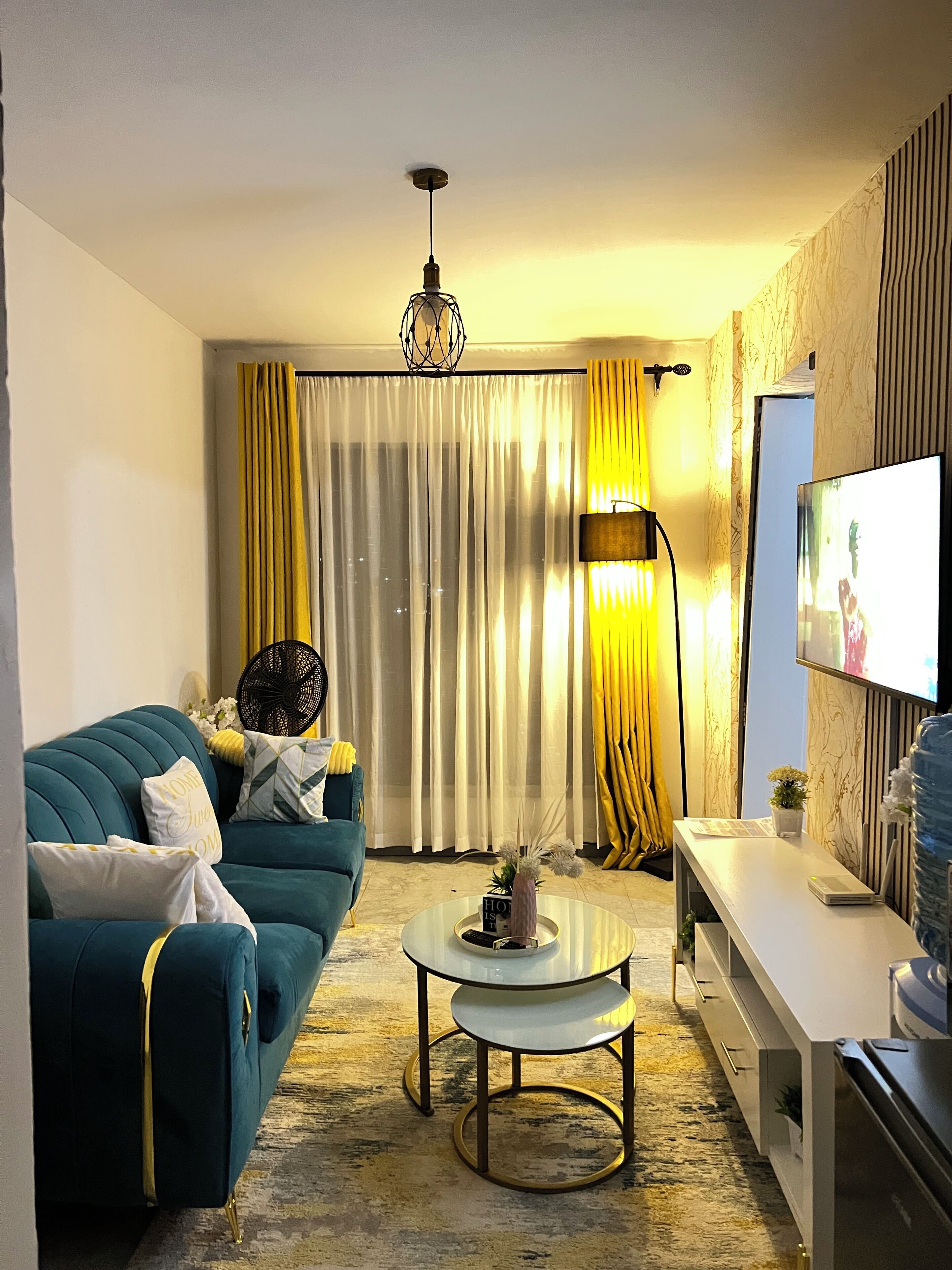 Un salon moderne avec un canapé, une table basse et un téléviseur.
