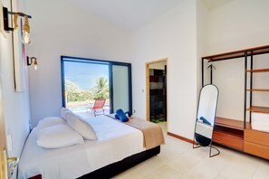 A bedroom with a bed, a mirror, a wardrobe, and a view of the outdoors.