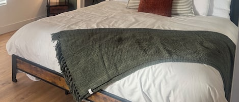 Tabla de planchar con plancha, internet y ropa de cama