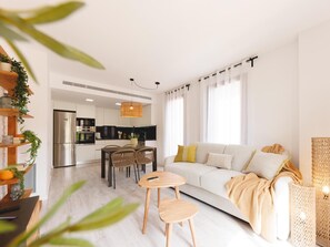 Una sala moderna con sofá, mesa de centro y comedor.