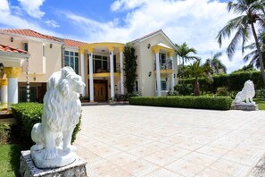 A large building with a curved facade, columns, and a statue of a lion. - La Perla by Suarez Properties | Pool, Jacuzzi, BBQ (Juan Dolio)
