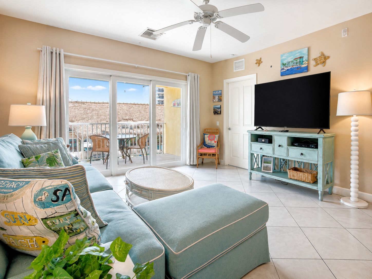 A living room with a sofa, a television, and a ceiling fan.