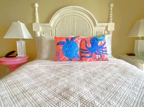 A bed with a white quilt, a white headboard, and two decorative pillows. - Harbour House #308 - "Beachcomber" (Fort Myers Beach)