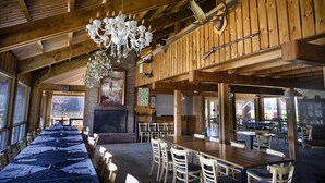 A spacious dining area with wooden tables and chairs, a chandelier, and a fireplace. - Two-Double Bedded Motel Room at Liscombe Resort (Liscomb)