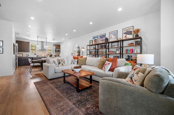 Ein modernes Wohnzimmer mit Sofa, Couchtisch und Bücherregal.