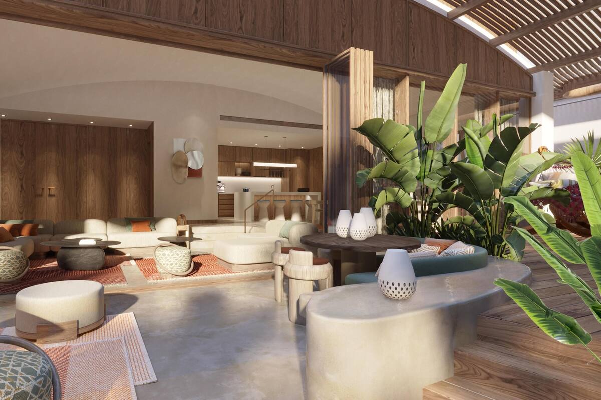 A spacious living area with a modern design, featuring a sofa set, a coffee table, and a dining table with chairs.