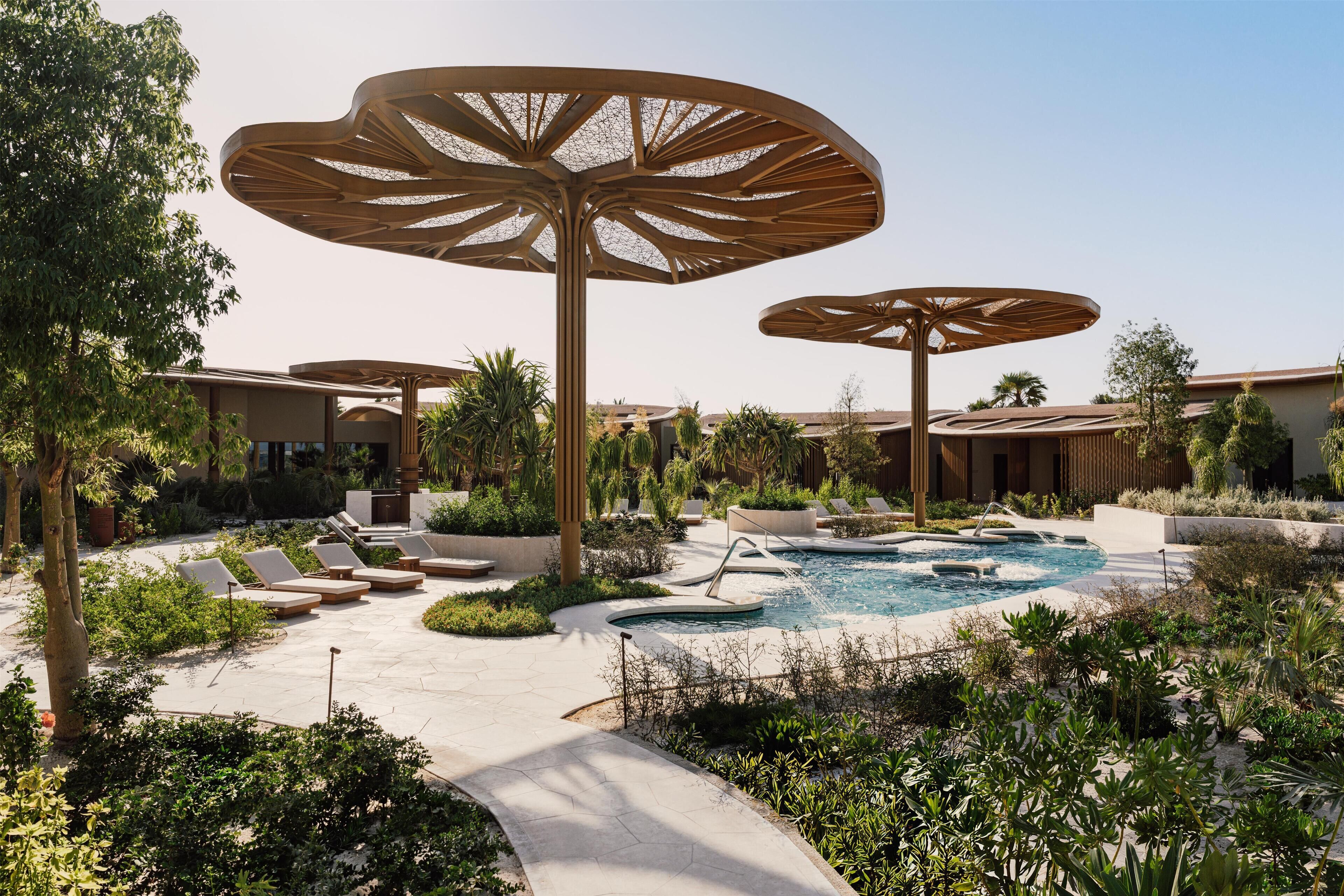A pool area with lounge chairs and large umbrellas.