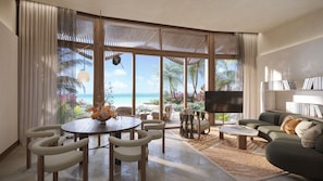 A spacious living area with a large window overlooking a beach, a round dining table with chairs, a sofa, and a flat-screen TV. - Miraval The Red Sea, Adults Only, All Inclusive Resort (Umluj)