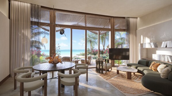 A spacious living area with a large window overlooking a beach, a round dining table with chairs, a sofa, and a flat-screen TV. - Miraval The Red Sea, Adults Only, All Inclusive Resort (Umluj)