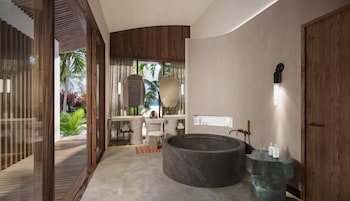 Un baño moderno con una bañera grande, un tocador con espejo y una zona de ducha.