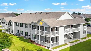 A multi-story residential building with balconies, a central courtyard, and a star on the roof. - Spacious newly renovated and furnished 3-bedroom condo in beautiful Gulf Shores (Gulf Shores)