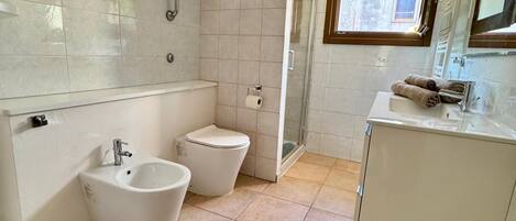 Een douche, een haardroger, een bidet, handdoeken
