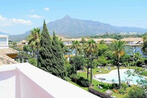 Ein Resort mit Pool, Palmen und einem Berg im Hintergrund.