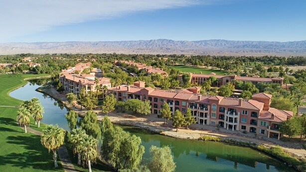 Um resort com vários edifícios, um campo de golfe e um rio.