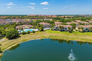 A residential area with houses, a swimming pool, and a body of water. - Blissful Disney Escape 2BR Minutes to Magic (Kissimmee)
