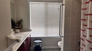 Une salle de bain avec un lavabo, des toilettes et une douche.