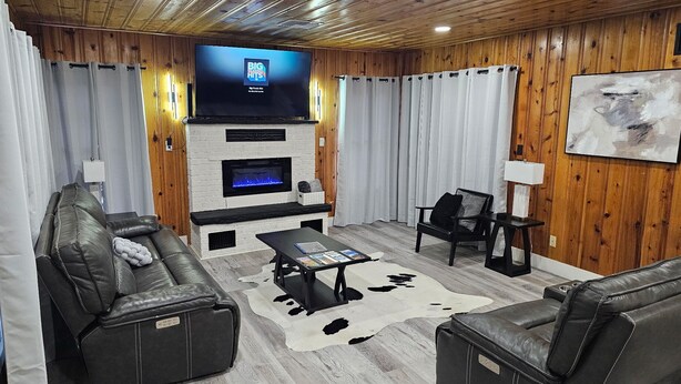 Una sala de estar con televisión, chimenea, sofás de cuero y alfombra de cuero de vaca.