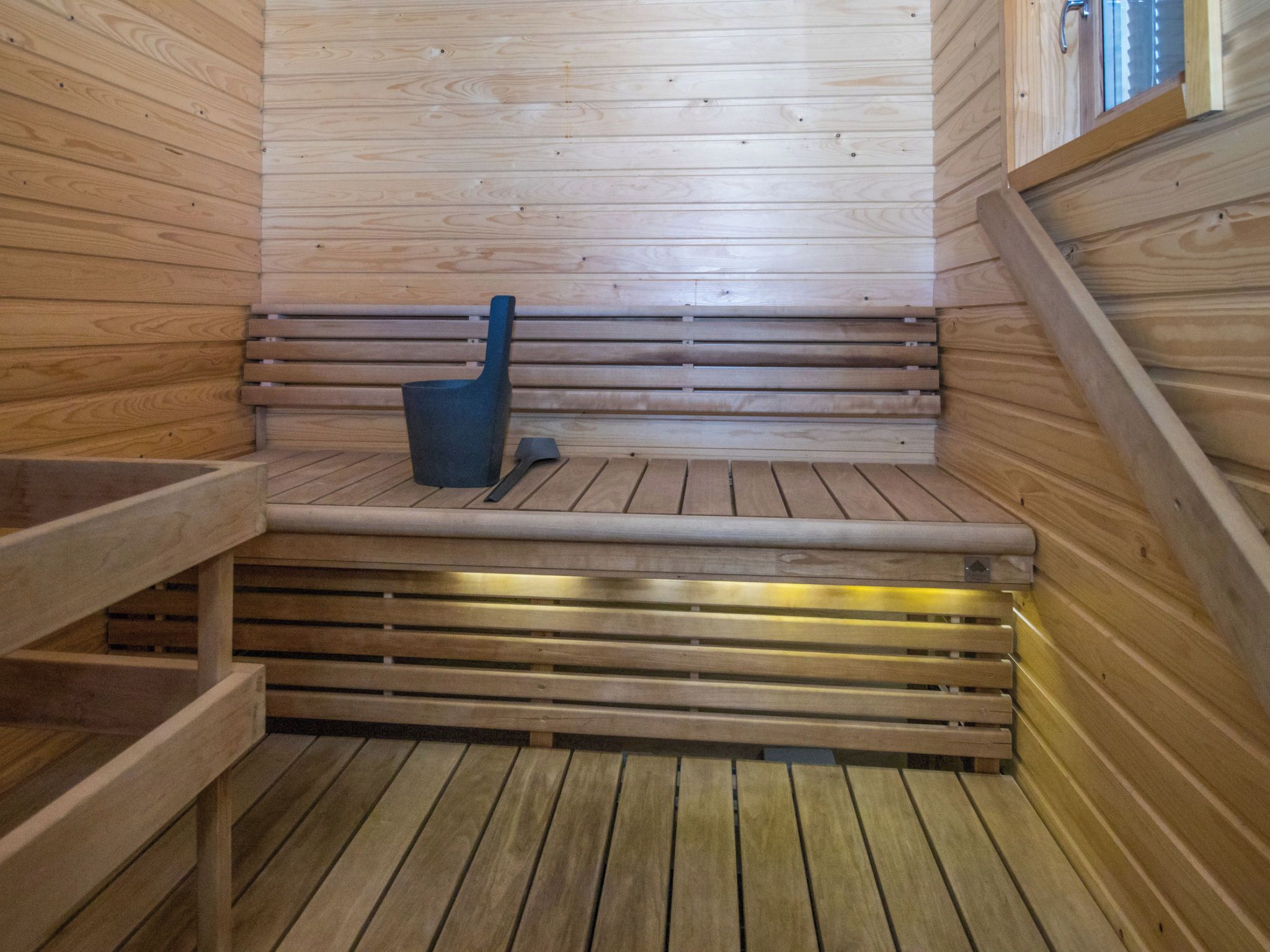 A wooden sauna with benches and a bench seat.