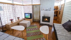 Una sala de estar acogedora con chimenea, televisor y sofá.