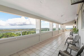 Ein Balkon mit Blick auf die Landschaft, mit gefliestem Boden und Gartenmöbeln.