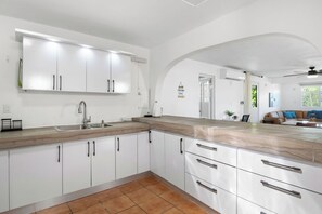 Eine moderne Küche mit weißen Schränken, einer Holz Arbeitsplatte und einer eingebauten Spüle.