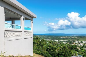 Ein weißes Gebäude mit einem Balkon mit Blick auf eine Küstenlandschaft.