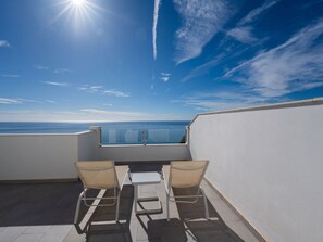 A rooftop terrace with a clear view of the sea, two chairs, and a small table. - Apartment  by Interhome (Nerja)
