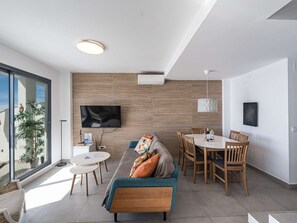 A modern living room with a sofa, coffee table, and dining area. - Apartment  by Interhome (Nerja)