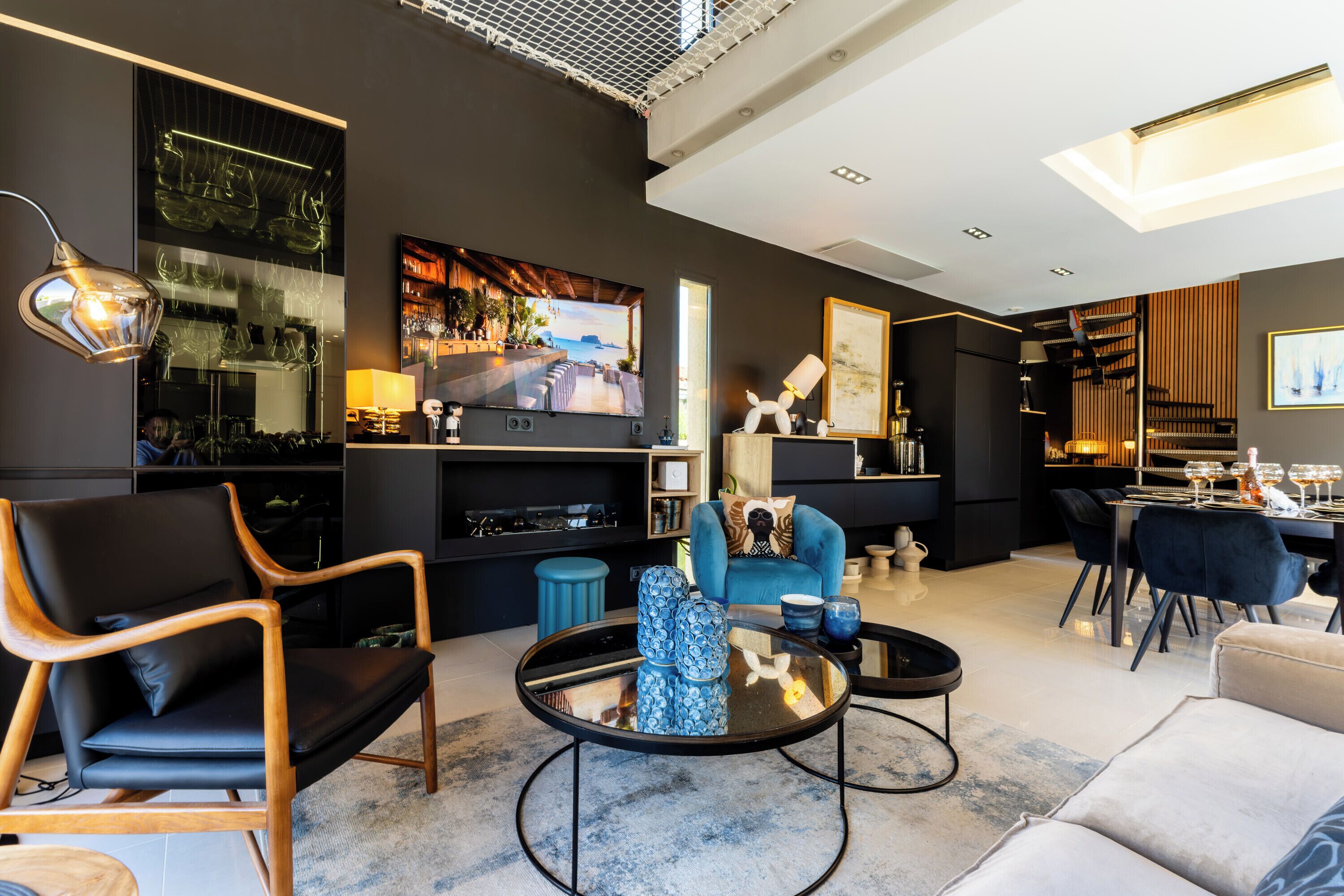 Un salon moderne équipé d’un téléviseur, de sièges et d’un coin bar.