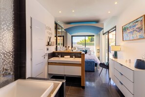 A modern bathroom with a large bathtub, a double sink vanity, and a shower area. - La Badoumba · Heated Pool & Jacuzzi (Saleilles)