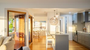 A modern kitchen with a central island, a dining area with a view, and a cozy seating area. - Seaview Escape in Ventnor (Ventnor)