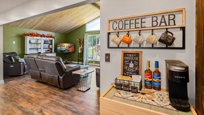Sala de estar com sofá seccional, barzinho com canecas e xarope Torani, e cafeteira Keurig.