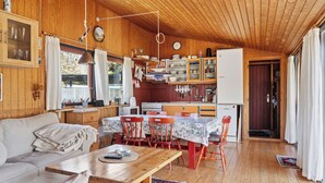 Un interior de cabaña acogedor con comedor, cocina y sala de estar con sofá.