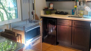 A kitchen with a microwave, dishwasher, and wooden cabinets. - Quaint 1-bedroom bed & breakfast with AC in Los Angeles (Los Angeles)