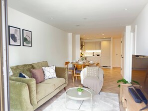 Ein modernes Wohnzimmer mit einer Couch, einem Couchtisch und einem Essbereich.