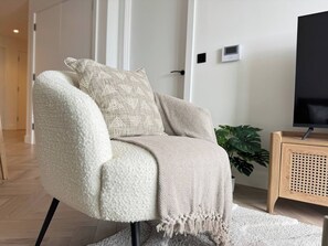 Ein modernes Wohnzimmer mit einer Couch, einem Fernseher und einem Holztischchen.