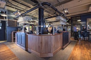 Eine Bar mit Holztresen, mehreren Zapfhähnen und einer Speisekarte.