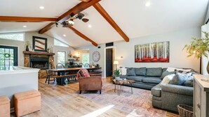 Un salón espacioso con chimenea, una mesa de comedor y un sofá.
