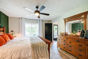 A bedroom with a bed, a dresser, a ceiling fan, and a view of the outdoors. - Lakefront Retreat w/ Private Dock, Firepit + Kayaks Sunset Views (Moneta)