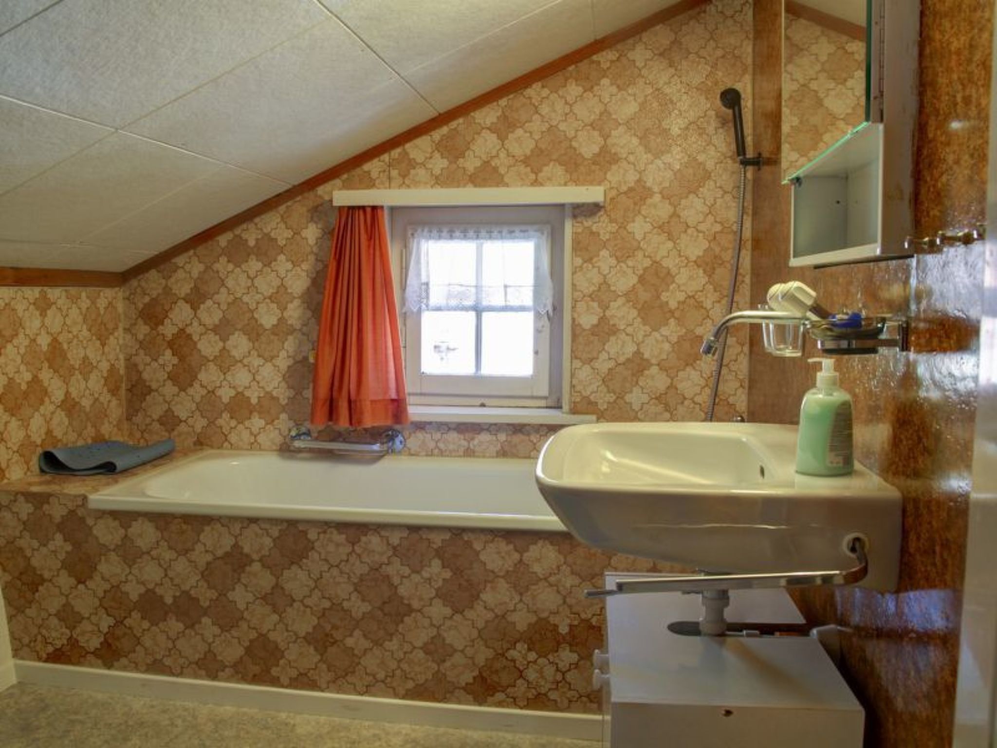 Ein Badezimmer mit einer Badewanne, einem Waschbecken, einem Fenster mit Vorhang und einer Dusche.